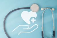 Zeigt ein Bild mit einer Hand die Herz hält mit einem Stethoskop.