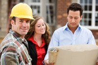 Das Bild zeigt einen Handwerker mit einem Helm, eine Frau und ein Mann mit einem Bauplan.
